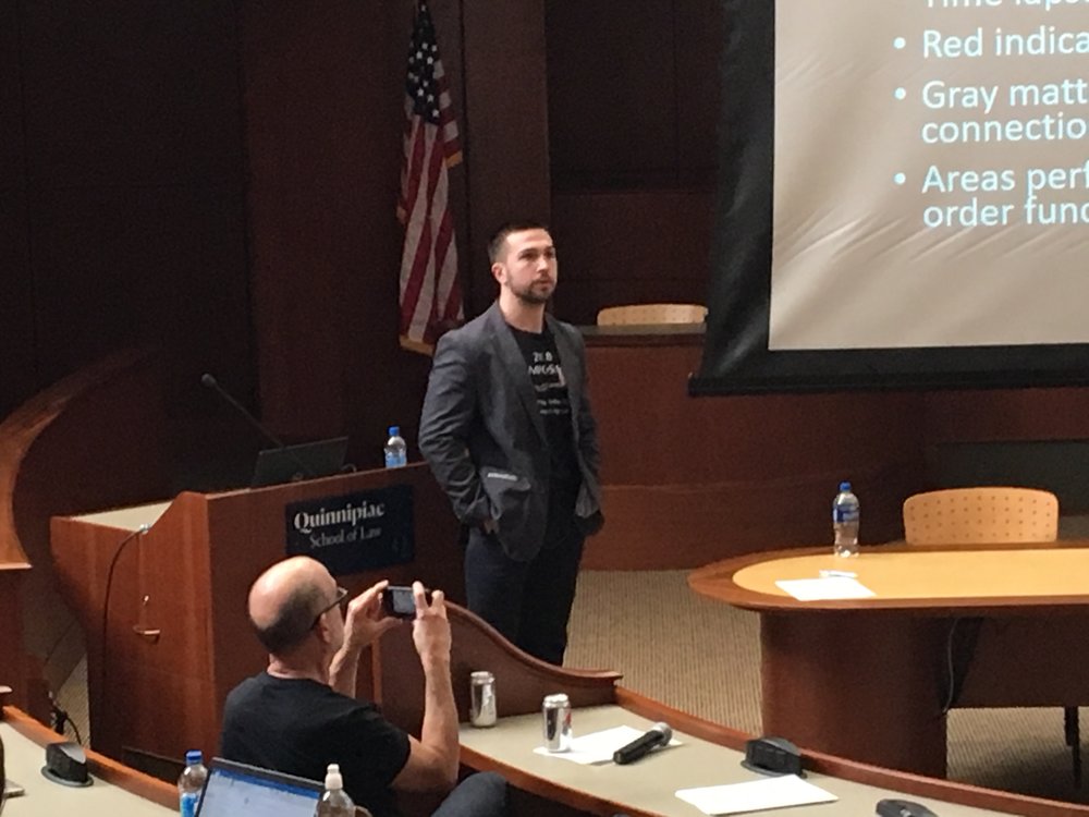 Brown University senior neuroscience student Caleb Brown explaining the relationship between epigenetics and the refugee experience.