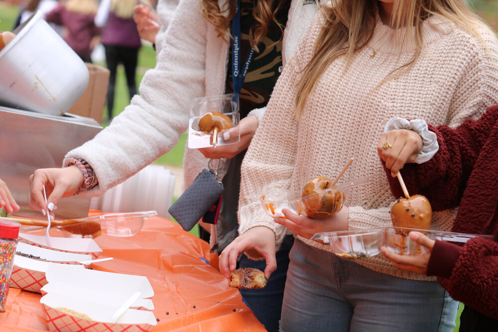 Students embracing the fall season by making their own caramel apples