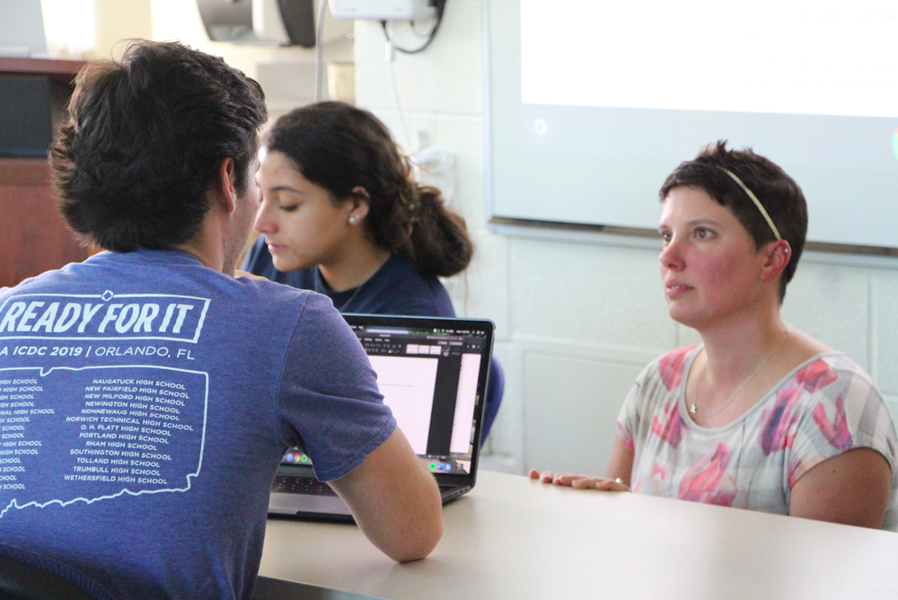 Professor Medina assisting a student with a question for a project.