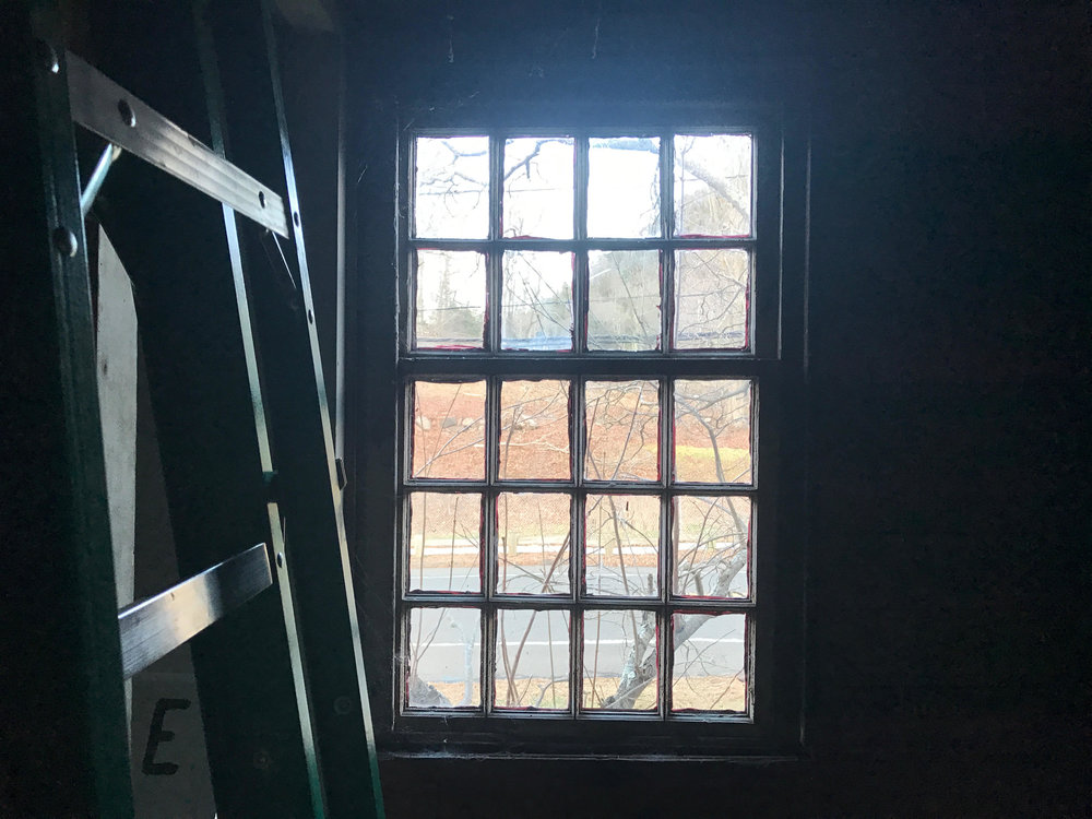 A ladder leans on a wall beside an upstairs hallway window that peeks out unto Mount Carmel Ave. Zoni’s ladder and other work tools take up some of the space upstairs during construction.