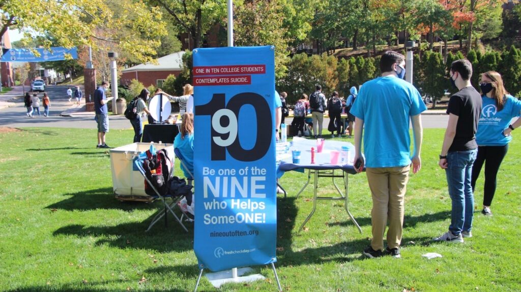 Students stand around the Nine out of Ten booth. The booth spreads awareness to the fact that One in ten college students contemplates suicide. That means nine out of ten students have the opportunity to help each one who is struggling. Take the Nine out of Ten pledge: be aware, speak up, reach out, and help someone especially during these tough times.
(Photo by Marianna Rappa)