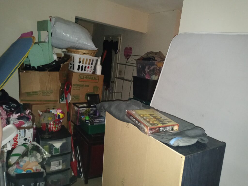 Boxes and belongings piled in a room