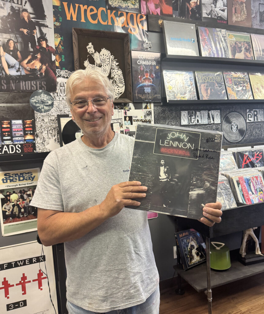 Armand Giorgio holds a copy of John Lennon’s Rock ‘N’ Roll, a nod to his record collecting journey. (Photo by Hailey Keel)