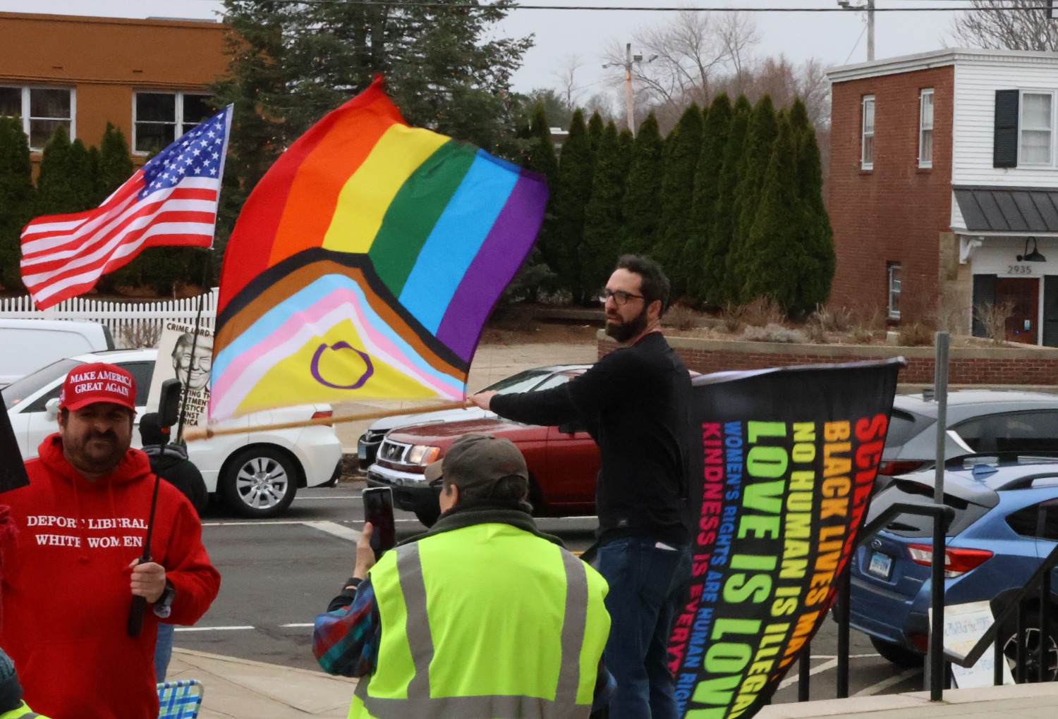 Andrew Rice, a Democratic candidate running for Congress, waves pride flags at the event, while counter-protester Robert Vardaro is visible nearby, reflecting the range of viewpoints present. Hannah Freshman/HQNN