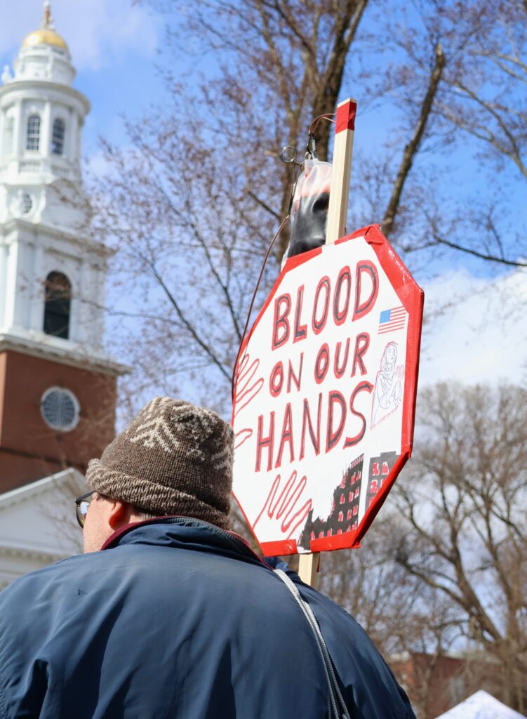 James Sterling of Bethany, CT displays a sign reading “Blood on Our Hands”. Hannah Freshman/HQNN