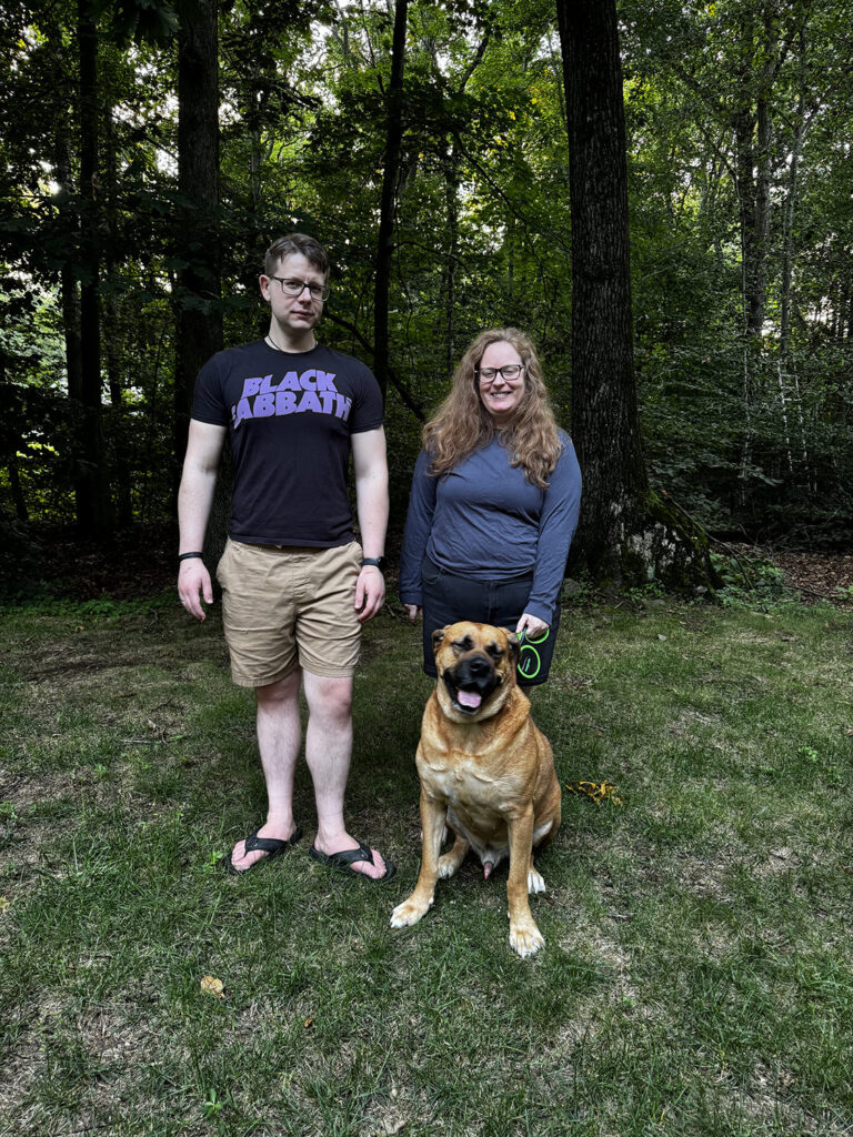 Sarah Mullhall and Coulson Hageman with their dog, Achilles, seen in the backyard of their home near Sleeping Giant on Aug. 13, 2026.