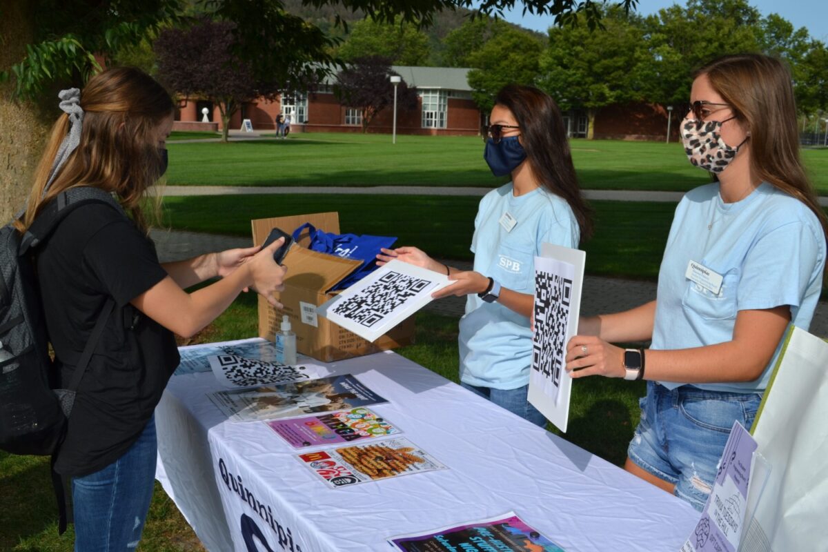 Kamryn Carter, junior biology major, psychology minor from Manchester, Conn. (left) and Shannon Flaherty, junior media studies major from Marshfield, Mass. (right) using a QR code to document applications for the Student Programming Board at Quinnipiac University. (photo by Owen Doody)