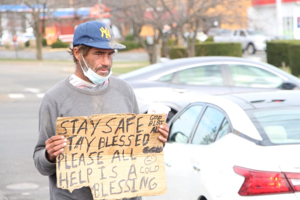 John Kennedy, 40, stands in the parking lot of the Hamden Mart shopping mall on Dixwell Avenue on Saturday, Nov. 21. Kennedy chose this spot to panhandle because it is located near a bank and other essential businesses. (Photo by Matt Nygaard)