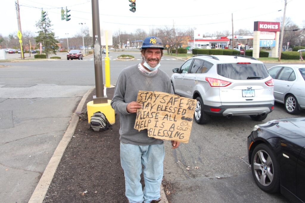 John Kennedy, 40, after the grey ford in the background drove by and he told them why he was being photographed. That person proceeded to give him a $20 bill. Kennedy mentioned how rare it is for that to happen, and said he thinks that because of the photos, "people are taking me more seriously." 