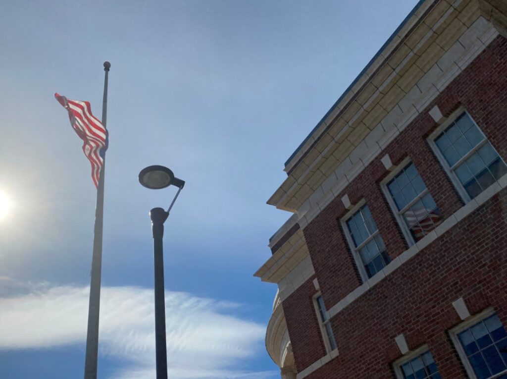 Flag flying at half staff front of the Hamden's town hall and fire department. Photo credit: Matthew Vulpis