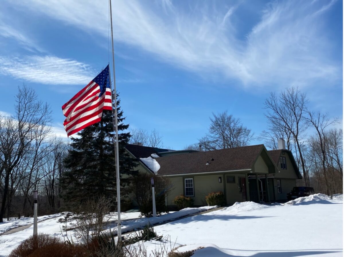 Flag at half staff outside QU human resource building. Photograph credit: Matthew Vulpis