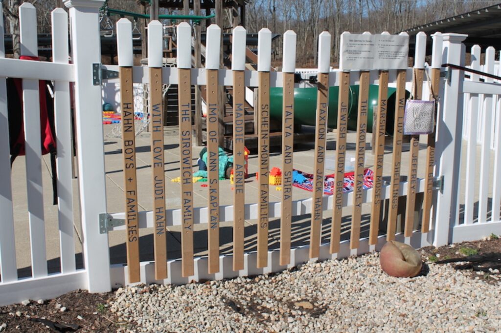 The fence in front of the playground at the Jewish Federation of Greater New Haven is inscribed with different community member's names. Photo by Jessica Simms
