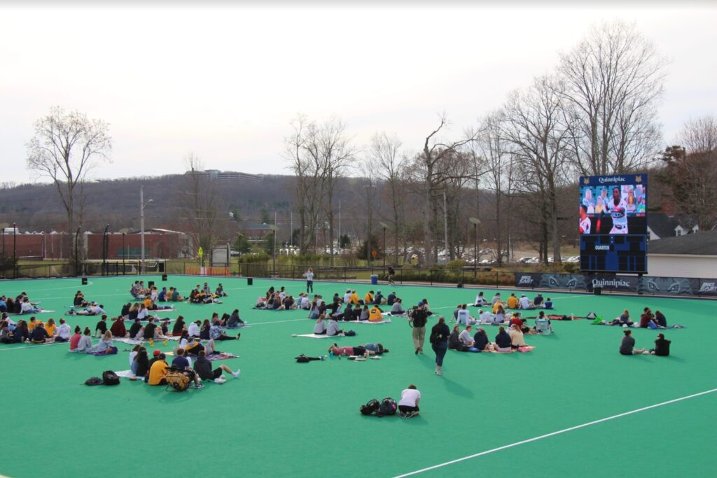 Quinnipiac students socially distancing to watch the NCAA playoff.  Credit: Lauryn Yarnall
