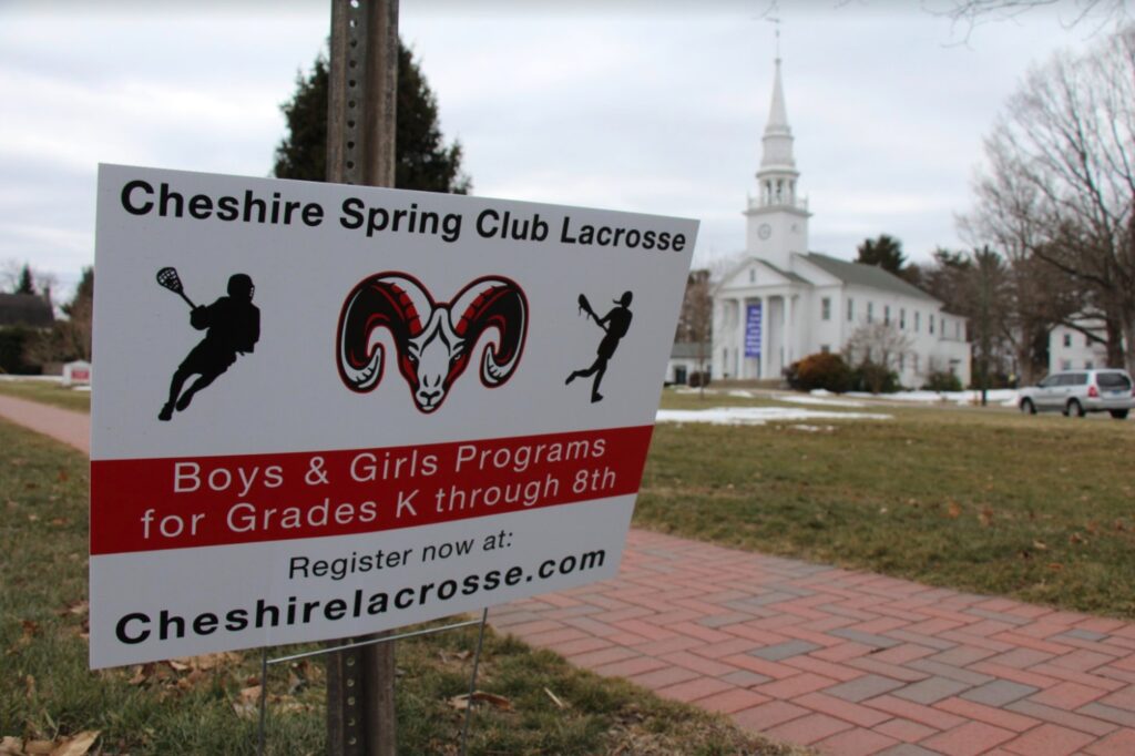 Signs advertising the start of Cheshire Spring Club lacrosse can be found all down Main Street in Cheshire. Photo Credit: Lo Yarnall