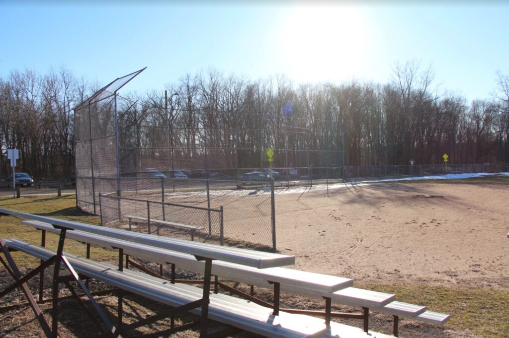 Empty bleachers overlook an empty field at Bassett Park in Hamden. 
Photo Credit: Lo Yarnall