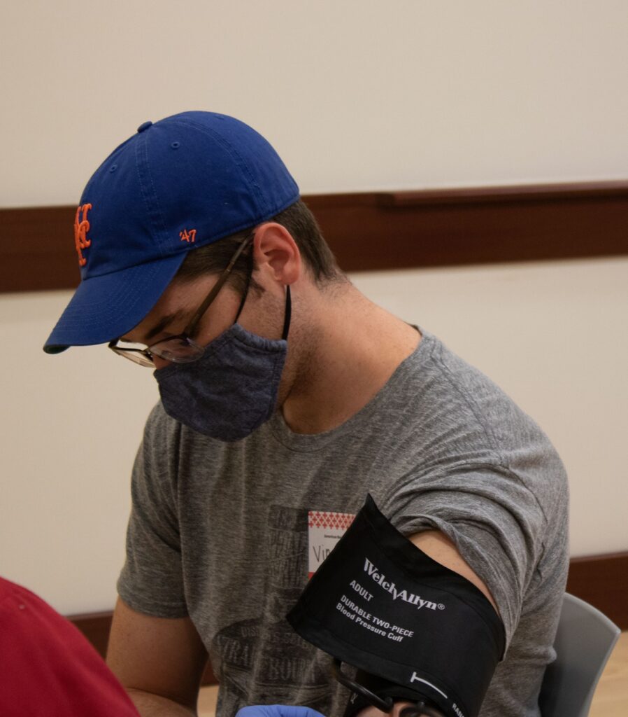 Vincent Vauman, a graduate student in the pathologist's assistant program at Quinnipiac, gets his blood pressure checked before he goes to donate blood. As someone with universal O-negative blood, his donation is particularly important. (Photo by Michael Sicoli)