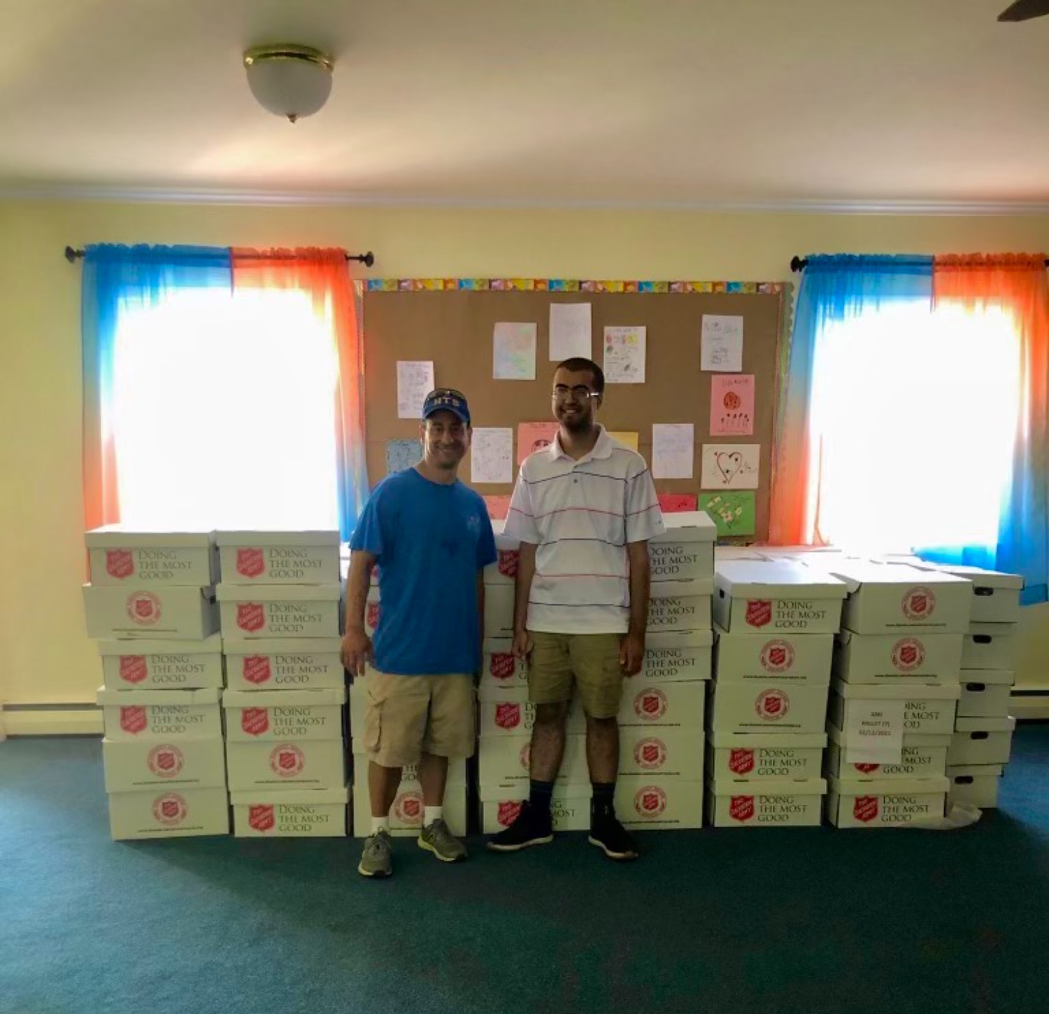 Rajan Doering, Quinnipiac student and leader of the GLOW Food Pantry stands with another volunteer in front of pre-made nonperishable food boxes. They filled a couple hundred and loaded up multiple vans to distribute them to local clientele and residents in need.