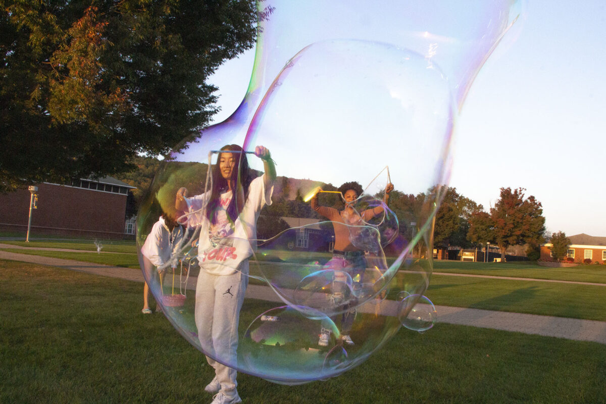 Julia Danehy, sophomore health sciences major, plays with bubbles on the Quad during the Multicultural Student Leadership Council's Culture Fair. Photo by Ashley Pelletier.