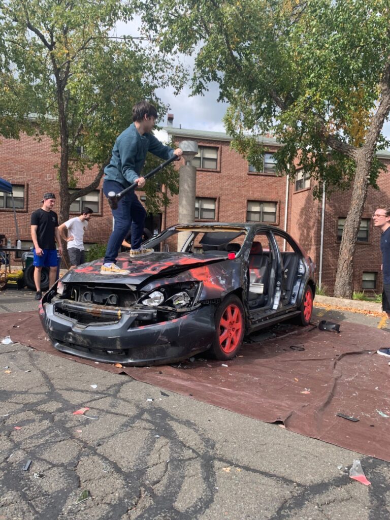 Student Sam Grauman gets on the hood to smash the dash - Photo by Alena DeLuise