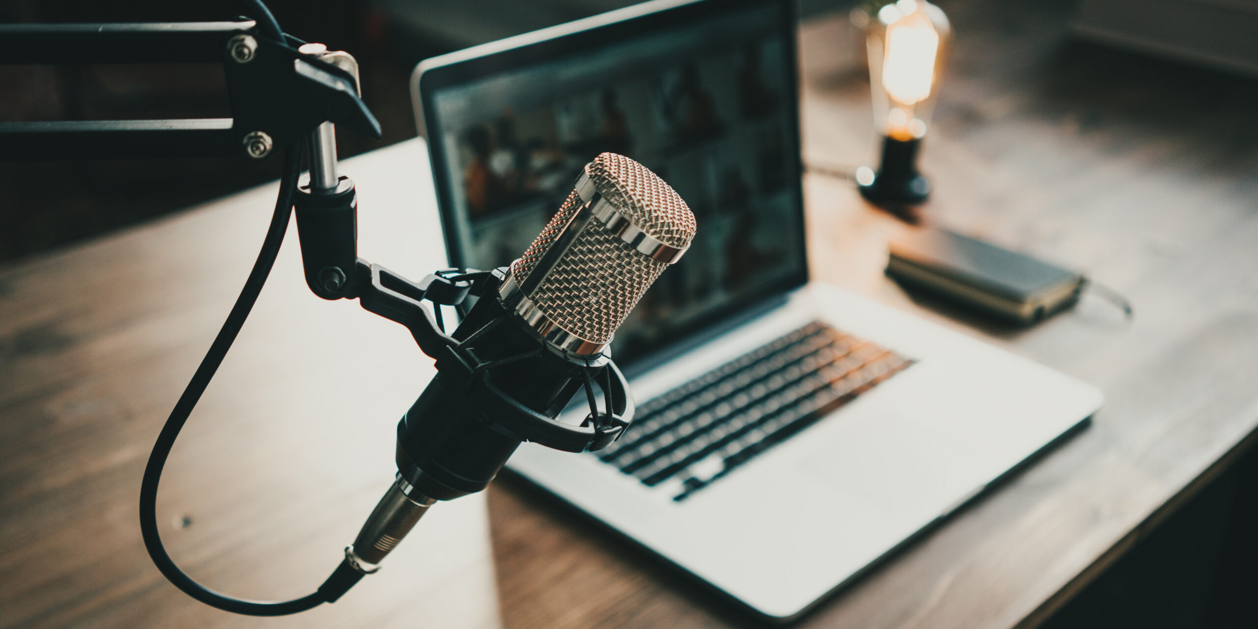 Home studio podcast interior. Microphone, laptop and on air lamp on the table, close-up. Photo by Alex from the Rock, Adobe Stock
