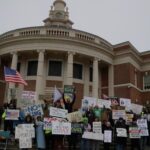 Protesters gather for a group photo at the conclusion of their weekly rally. Hannah Freshman/HQNN