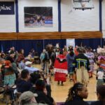 A diverse crowd of onlookers watches Indigenous dancers during the second annual Powwow. Originally planned for the Mount Carmel quad, the 2026 ceremony served as a powerful reminder of the community's shared commitment to inclusion, regardless of the setting. Hannah Freshman/HQNN